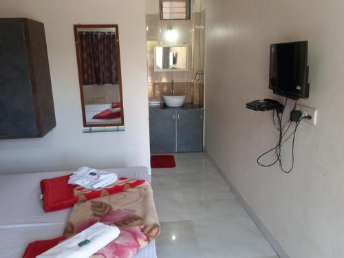 a room with a bathroom with a sink and a mirror at Swami Leela Relax Inn in Mahabaleshwar