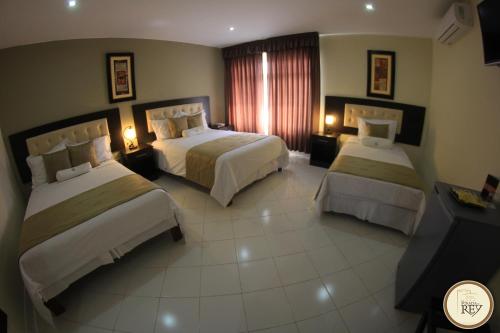 a hotel room with two beds and a window at Posada del Rey Hotel in Trujillo