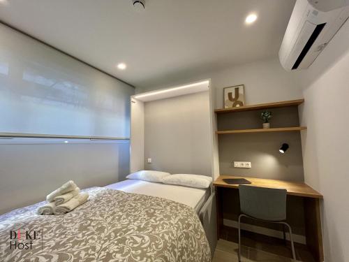 niewielka sypialnia z łóżkiem i biurkiem w obiekcie Duke Vallehermoso Apartament w Madrycie