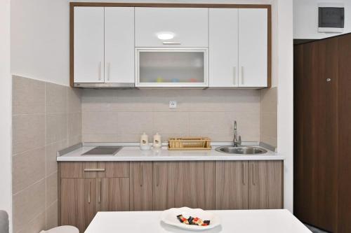 a kitchen with white cabinets and a sink at Apartment White Bear in Zlatibor