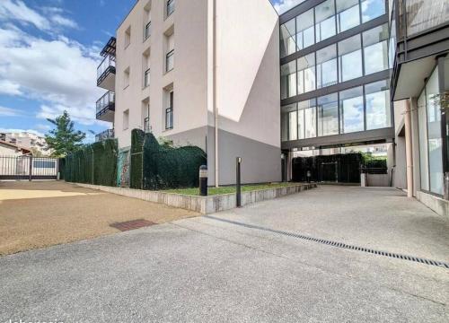 un parcheggio vuoto di fronte a un edificio di Bel appartement rénové proche Lyon a Saint-Priest