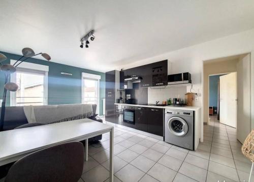 una cucina e un soggiorno con lavatrice di Bel appartement rénové proche Lyon a Saint-Priest