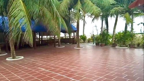 a resort with palm trees and a tile floor at HaiAu Hotel in Quất Lâm