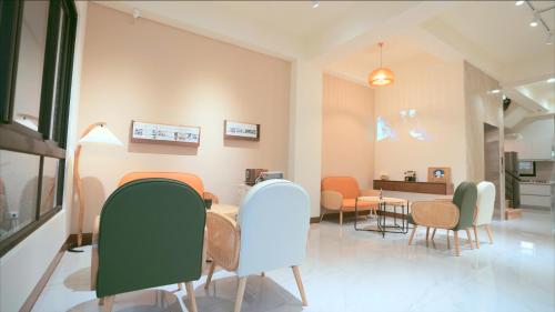 - une salle d'attente avec des chaises et une table dans l'établissement 咻咻宿 Xiuxiu 電梯宅, à Taïtung