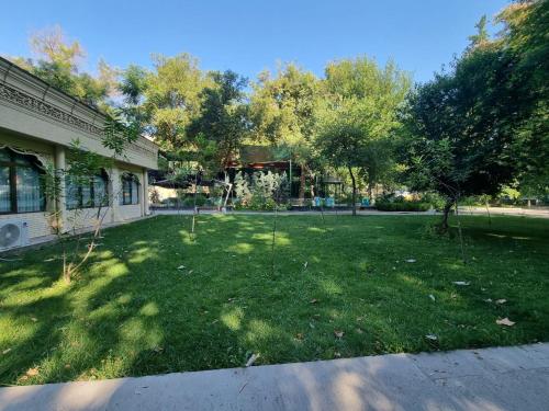 a yard in front of a building with trees at City Center Apartment 1 in Tashkent
