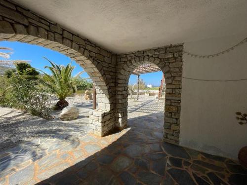 a stone archway on a building with a palm tree at Ariadne's apartment - Apollonas in Apollon