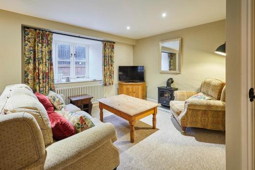 a living room with two couches and a table at Host & Stay - Tithe Barn Cottages in Easington