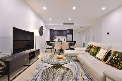 a living room with a couch and a tv at Leichhardt Serene Retreat - Views丨Parking丨Ease in Sydney