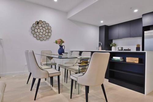 a dining room with a glass table and chairs at Leichhardt Serene Retreat - Views丨Parking丨Ease in Sydney