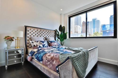 a bedroom with a bed with a large window at Leichhardt Serene Retreat - Views丨Parking丨Ease in Sydney