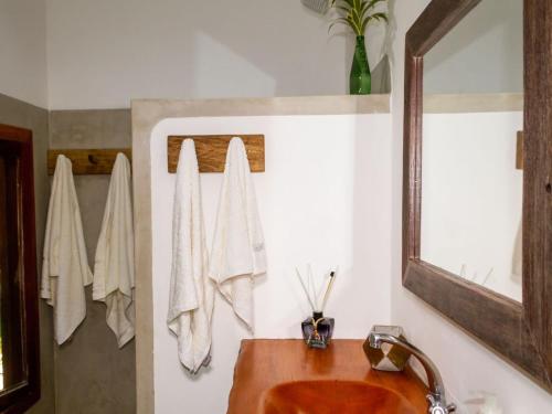 a bathroom with a sink and a mirror at CASA SIMONI Trancoso in Trancoso