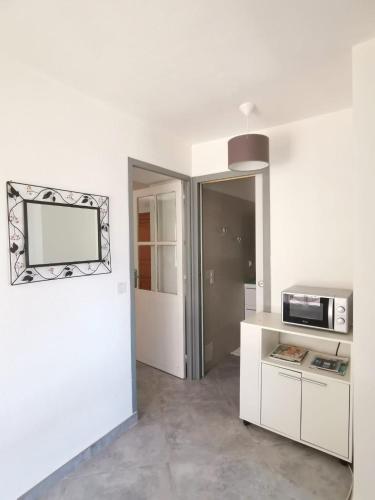 a kitchen with white cabinets and a microwave at Villa Giuseppina in Bonifacio