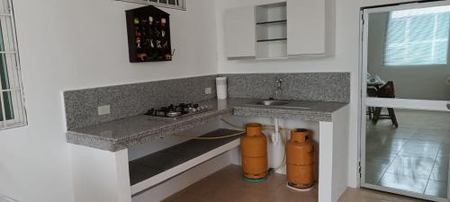 una cocina con dos bocas de fuego anaranjadas bajo un mostrador en Casa para 10 personas - Playas, Villamil, en Playas