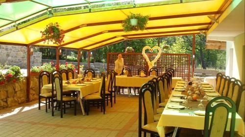 a restaurant with tables and chairs and a person in the background at Grandemi Belvedere Bucovina in Frasin