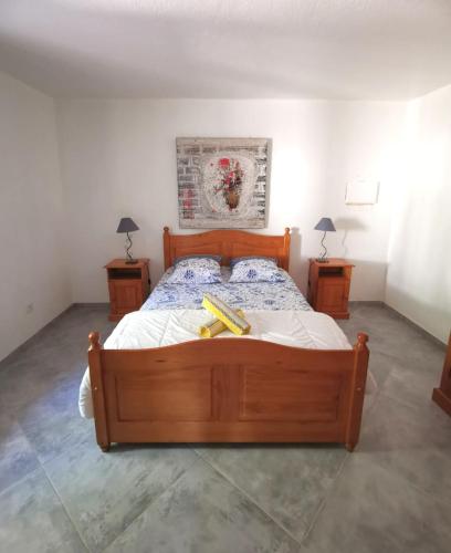 1 dormitorio con 1 cama de madera y 2 mesitas de noche en Villa Giuseppina, en Bonifacio