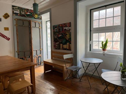 a dining room with a table and chairs and a window at Alface Hall Hostel & Bar in Lisbon