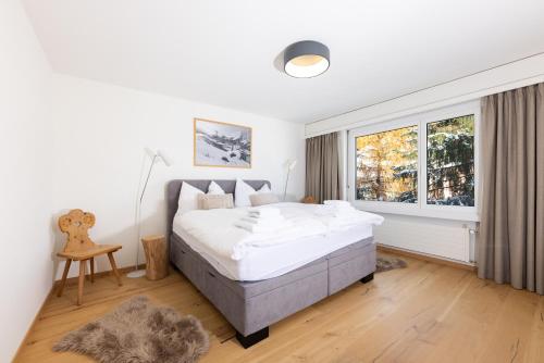 una camera con un grande letto e una finestra di Modern crossing apartment facing Piz Rosatsch a Sankt Moritz