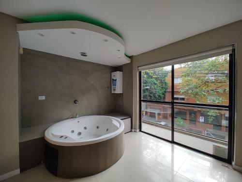 a large bathroom with a tub and a large window at Shallor Cryss in San Miguel de Tucumán