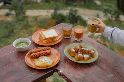 a table with plates of food and two glasses of beer at SZ Samui Glamping in Ban Sa Ket