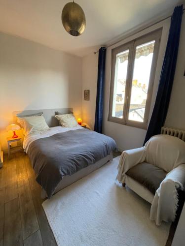 ソミュールにあるCosy Flat vue château Loire à veloのベッドルーム1室(ベッド1台、ソファ、窓付)