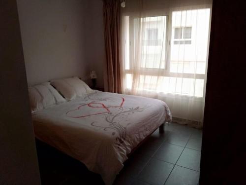 a bedroom with a bed and a window at Holikeys - Agadir - 2 Ch - El Houda 001 in Agadir