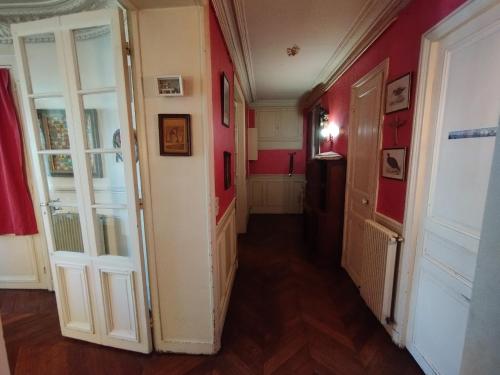 a hallway with red walls and white doors at Chambre spacieuse - Trocadéro in Paris