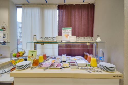 a table with plates and utensils in a room at Brit Hotel Lille Centre in Lille