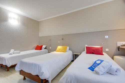 a room with two beds with colorful pillows on them at Brit Hotel Lille Centre in Lille