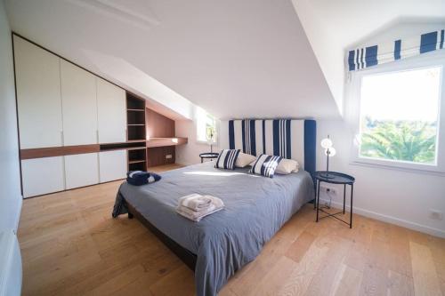 1 dormitorio con cama y ventana grande en Villa Fortune - 11 couchages - Piscine & Tennis, en Bayona