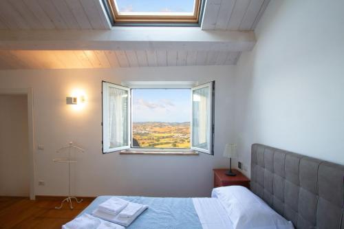 a bedroom with a bed and two windows at Casa Le Fonti Casa vacanze in Osimo