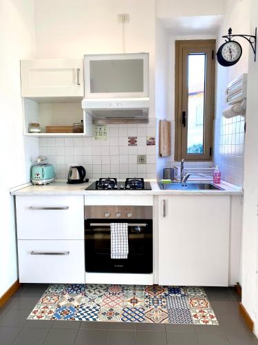 a white kitchen with a stove and a sink at Il Casone in Cernobbio