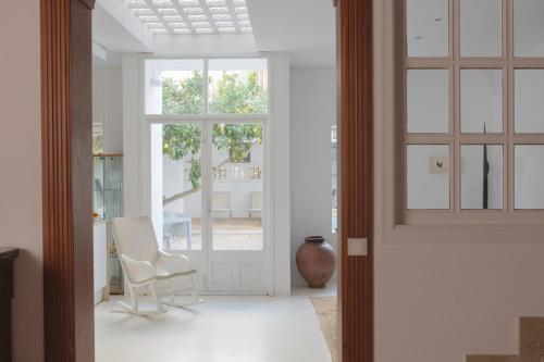 a living room with white chairs and a glass door at Ca Sa Padrina d'Artà-Turismo de Interior in Artá