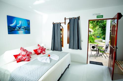 een slaapkamer met een bed met rode kussens erop bij Pousada Villa Caju in Jericoacoara