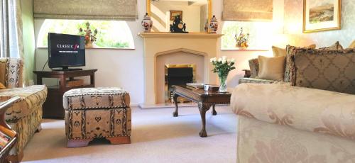 a living room with a couch and a fireplace at The Saddlery Holiday Cottage - Near Wolds And Coast in North Thoresby