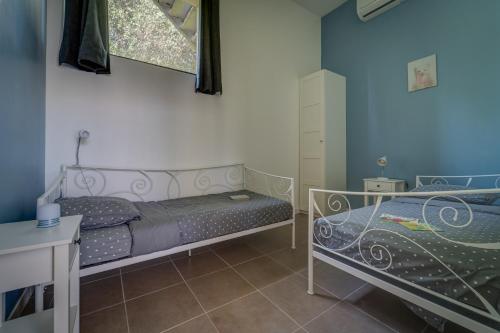 1 Schlafzimmer mit 2 Betten und einem Fenster in der Unterkunft Gîte Imagine Roussillon Résidence Privée avec Piscine - 5 personnes in Canet-en-Roussillon