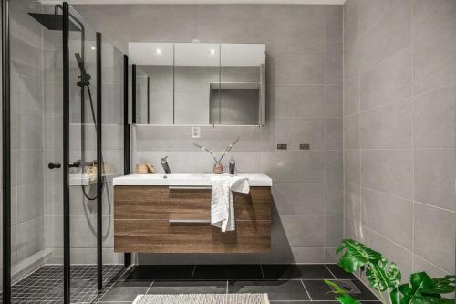 y baño con lavabo y espejo. en Homerentals l 120sqm Mid-central - King beds - 500Mbps WI-FI, en Bergen