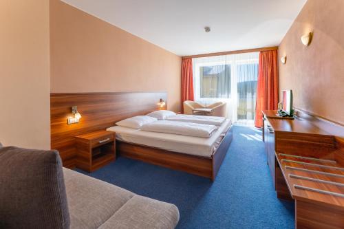 a hotel room with a bed and a television at Lipno Wellness - Frymburk C104 privat family room in Frymburk