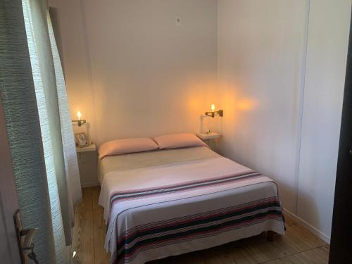 a small bed in a white room with two lights at PIRIA in Playa Hermosa