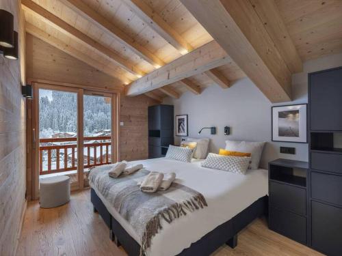 a bedroom with a large bed with two towels on it at 3 Fontaines - Apt C1 - BO Immobilier in Châtel