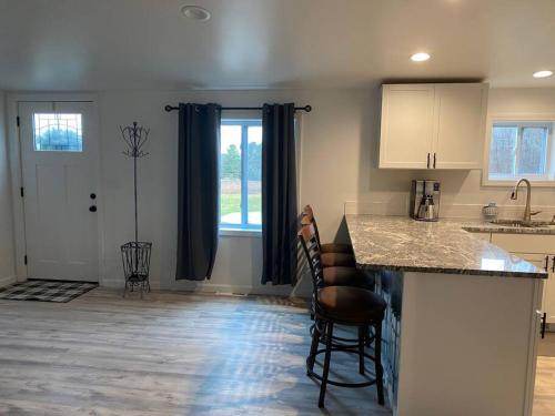 a kitchen with a counter and chairs in a room at Cozy Country Home Near Boyne City and Boyne Mt in Boyne City