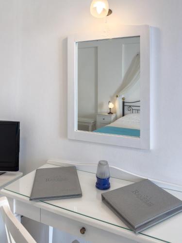 a desk with two laptops on it with a mirror at Reverie Santorini Hotel in Firostefani