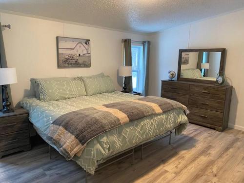 a bedroom with a bed and a large mirror at Cozy Country Home Near Boyne City and Boyne Mt in Boyne City