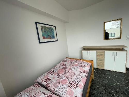 ein kleines Schlafzimmer mit einem Bett und einer Kommode in der Unterkunft Zimmer Vermietung in Pattensen