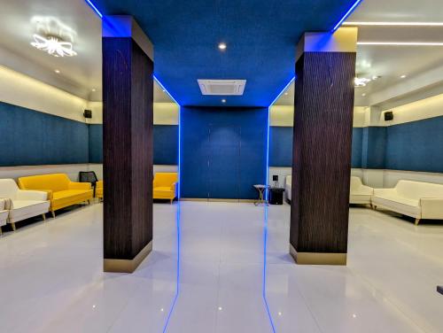 a lobby with blue ceilings and yellow chairs at Hotel Red Chillee Restro in Silvassa