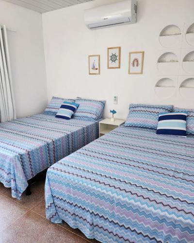 two beds sitting next to each other in a bedroom at CASA EM SERRAMBI in Porto De Galinhas