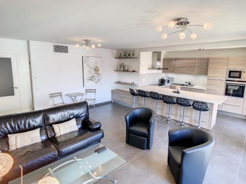 Il comprend un salon avec un canapé en cuir noir et une cuisine. dans l'établissement 3 Bedrooms, 3 bathrooms central Cannes Lecerf 411, à Cannes