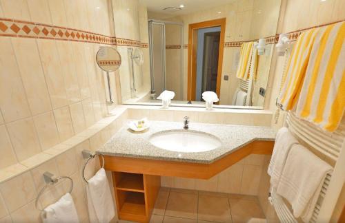 a bathroom with a sink and a mirror at Best Western Plus Hotel Alpenhof in Oberstdorf