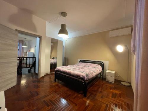 a bedroom with a bed and a wooden floor at Garden suite / del ducato in Parma