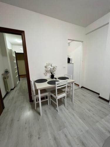 a white dining room with a table and chairs at Your home outlet 4 in Serravalle Scrivia