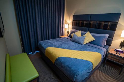 a hotel room with a bed and a green chair at The Eagle Suite at Stoneridge Mountain Resort in Canmore